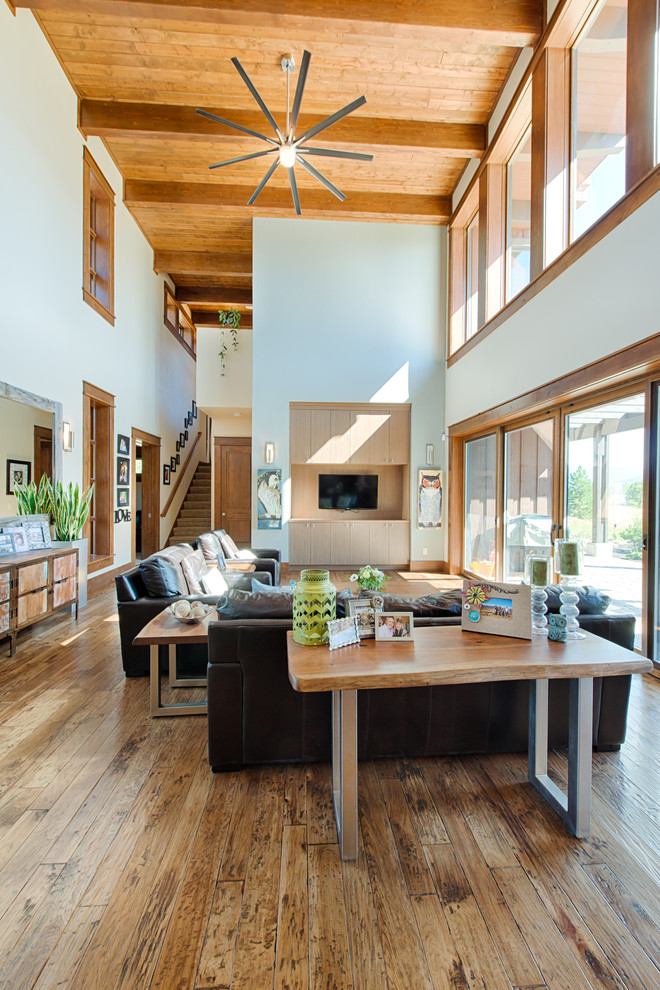 Cette photo montre un grand salon tendance ouvert avec une salle de réception, un mur blanc, un sol en bois brun et un téléviseur encastré.