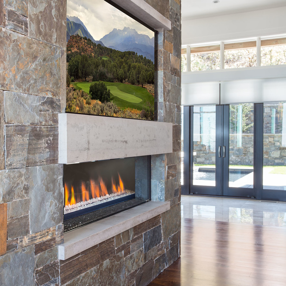Photo of an expansive contemporary formal open plan living room in Salt Lake City with white walls, dark hardwood flooring, a two-sided fireplace and a stone fireplace surround.
