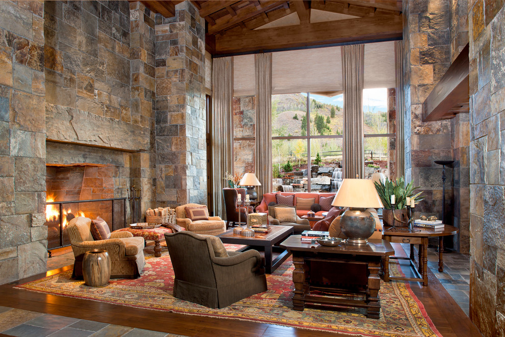 Photo of a rustic living room in San Francisco with dark hardwood flooring, a standard fireplace, a stone fireplace surround and no tv.