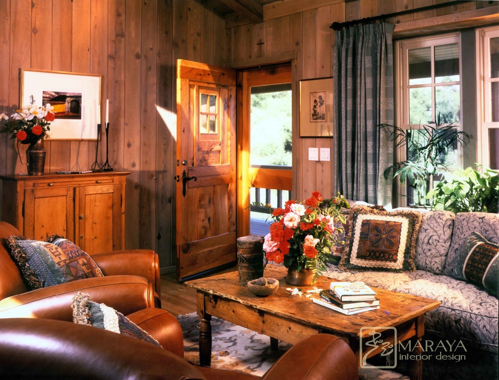 Cette image montre un salon rustique de taille moyenne et ouvert avec parquet clair, une salle de réception, une cheminée standard, un manteau de cheminée en pierre, un téléviseur fixé au mur et un mur beige.
