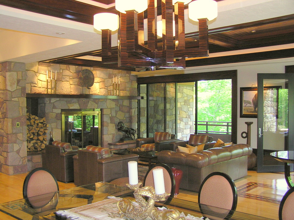 Foto de salón para visitas abierto asiático grande sin televisor con paredes blancas, suelo de madera clara, chimenea de doble cara y marco de chimenea de piedra