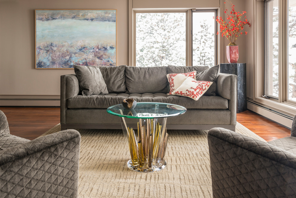 Immagine di un soggiorno design con pareti beige e pavimento in legno massello medio