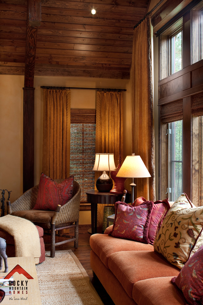 Immagine di un soggiorno rustico di medie dimensioni e aperto con sala formale, pareti gialle, parquet chiaro, camino classico e cornice del camino in pietra