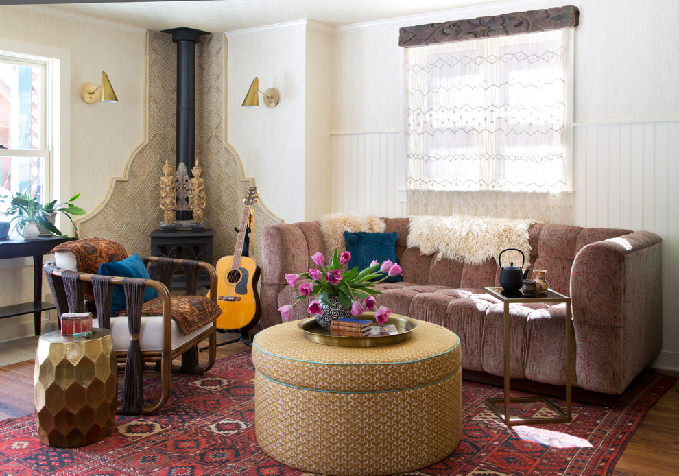Inspiration for an eclectic living room in Denver with white walls, medium hardwood flooring and a wood burning stove.