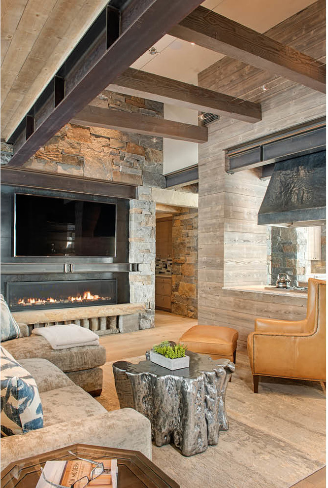 Идея дизайна: большая открытая гостиная комната в стиле рустика с домашним баром, горизонтальным камином, фасадом камина из камня, телевизором на стене, бежевыми стенами, паркетным полом среднего тона и коричневым полом
