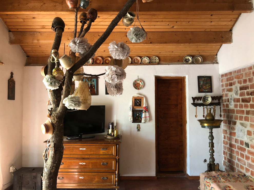 Immagine di un soggiorno rustico di medie dimensioni e aperto con pavimento in terracotta, stufa a legna, travi a vista e pareti in mattoni