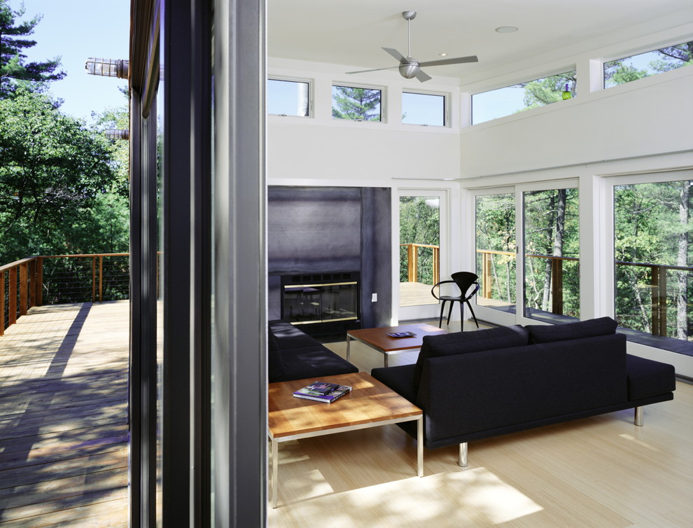 Cette image montre un salon minimaliste avec un mur blanc, aucun téléviseur et canapé noir.