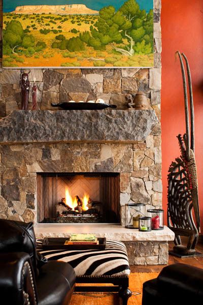 Foto de salón para visitas abierto rural grande con paredes rojas, suelo de madera en tonos medios, chimenea lineal y marco de chimenea de piedra