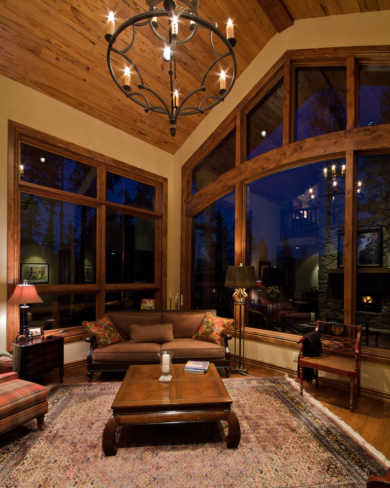 Mittelgroßes Uriges Wohnzimmer mit beiger Wandfarbe, braunem Holzboden und braunem Boden in Denver