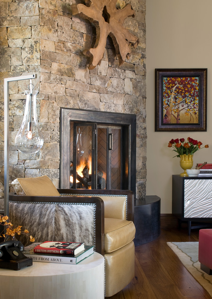 デンバーにあるラスティックスタイルのおしゃれなリビング (コーナー設置型暖炉、石材の暖炉まわり) の写真