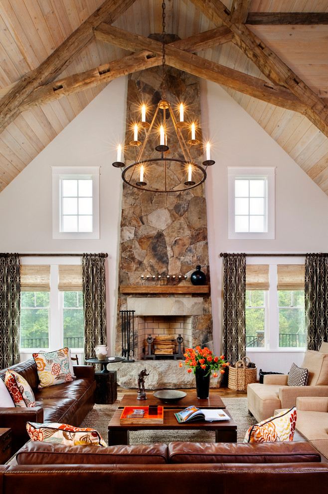 Aménagement d'un grand salon montagne avec un mur beige, un sol en bois brun, une cheminée standard et un manteau de cheminée en pierre.