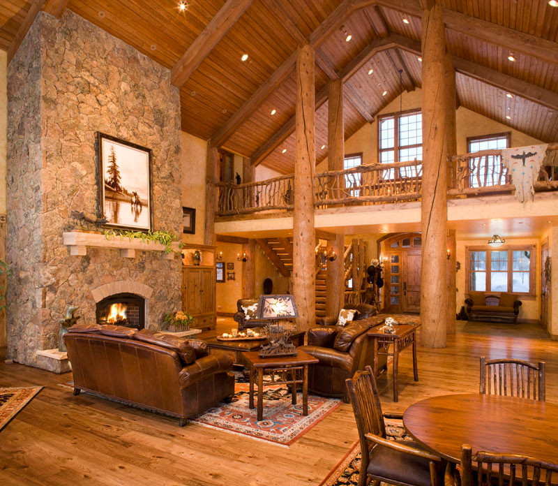 Large mountain style formal and open concept medium tone wood floor living room photo in Denver with beige walls, a standard fireplace, a stone fireplace and no tv