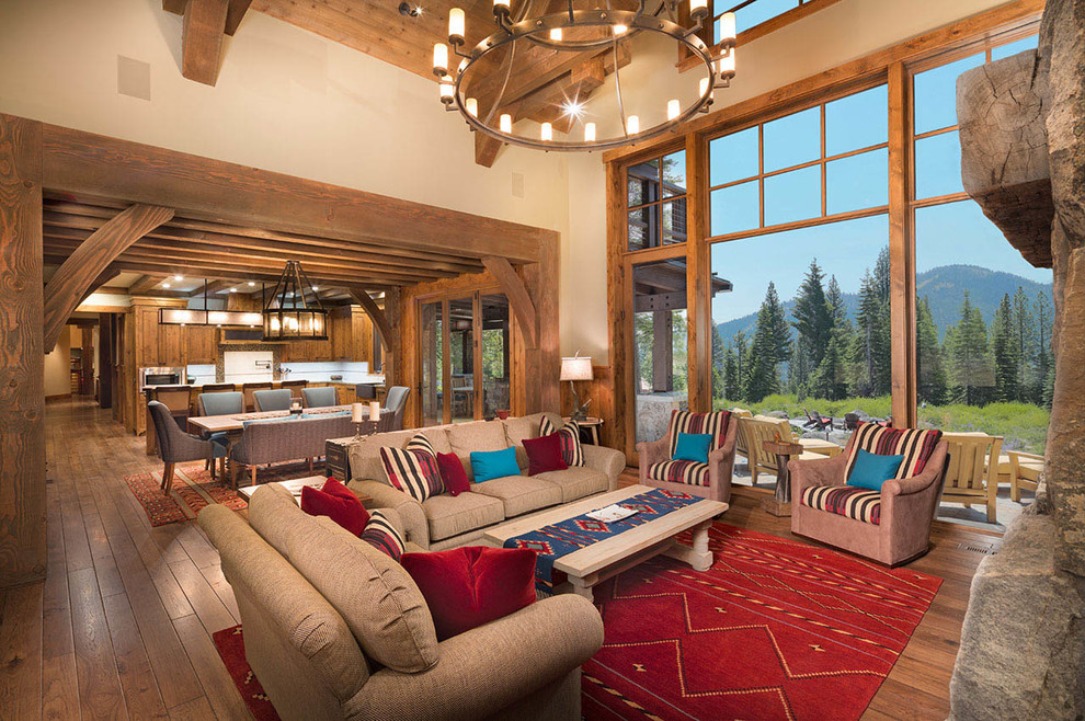 This is an example of a large rustic formal open plan living room in Other with beige walls, dark hardwood flooring, a standard fireplace, a stone fireplace surround, no tv and feature lighting.