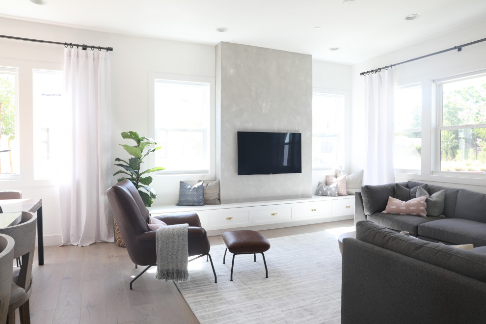Imagen de salón abierto de estilo americano grande sin chimenea con paredes grises, suelo de madera en tonos medios, televisor colgado en la pared y suelo marrón
