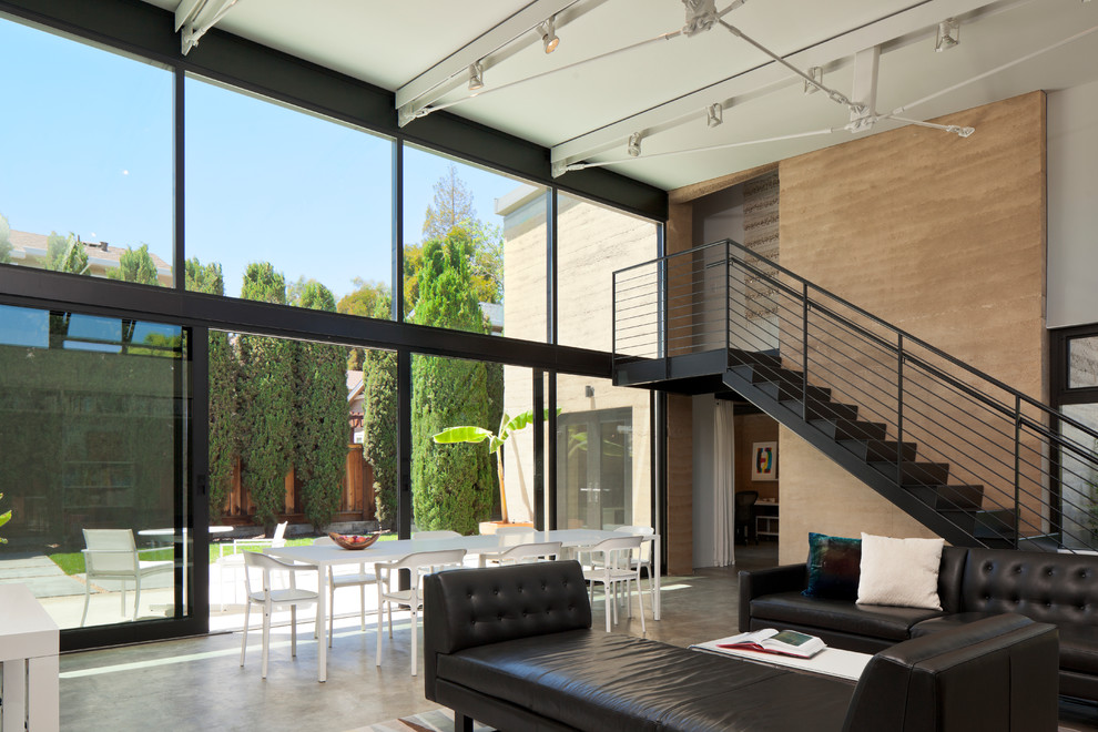Foto de salón para visitas abierto moderno de tamaño medio sin chimenea con paredes marrones y suelo de cemento