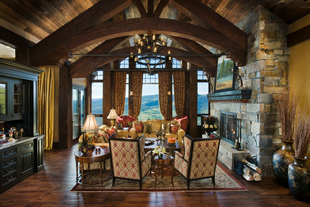 This is an example of an expansive rustic living room in Other with a standard fireplace, a stone fireplace surround and no tv.