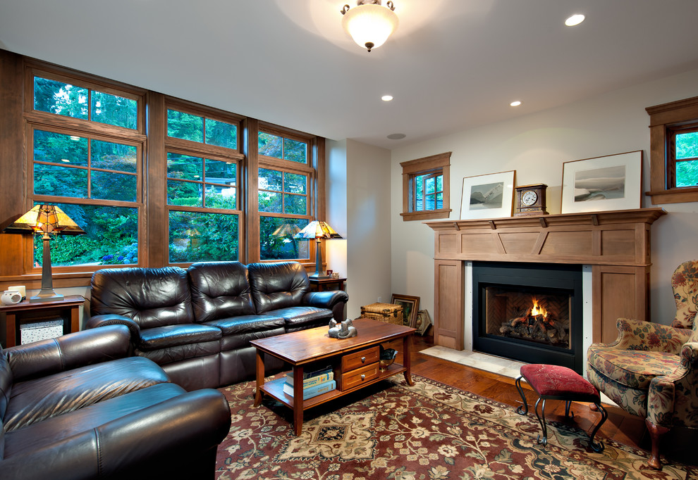 This is an example of a large modern formal enclosed living room in Vancouver with dark hardwood flooring, a standard fireplace, a wooden fireplace surround and brown floors.