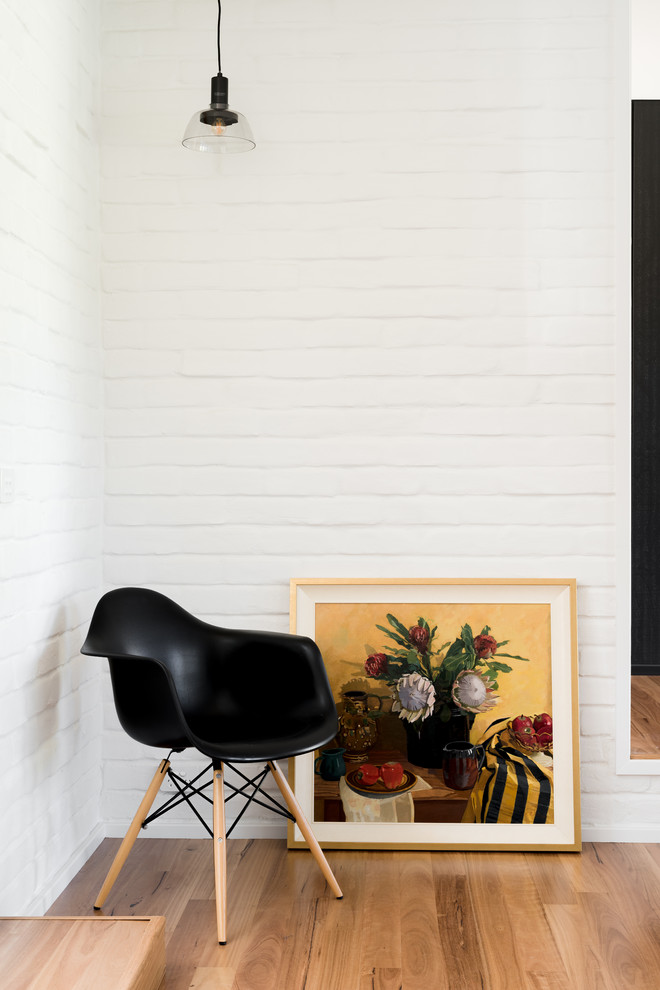 Cette photo montre un grand salon rétro ouvert avec un mur blanc, un sol en bois brun, une cheminée double-face, un manteau de cheminée en carrelage et un téléviseur indépendant.