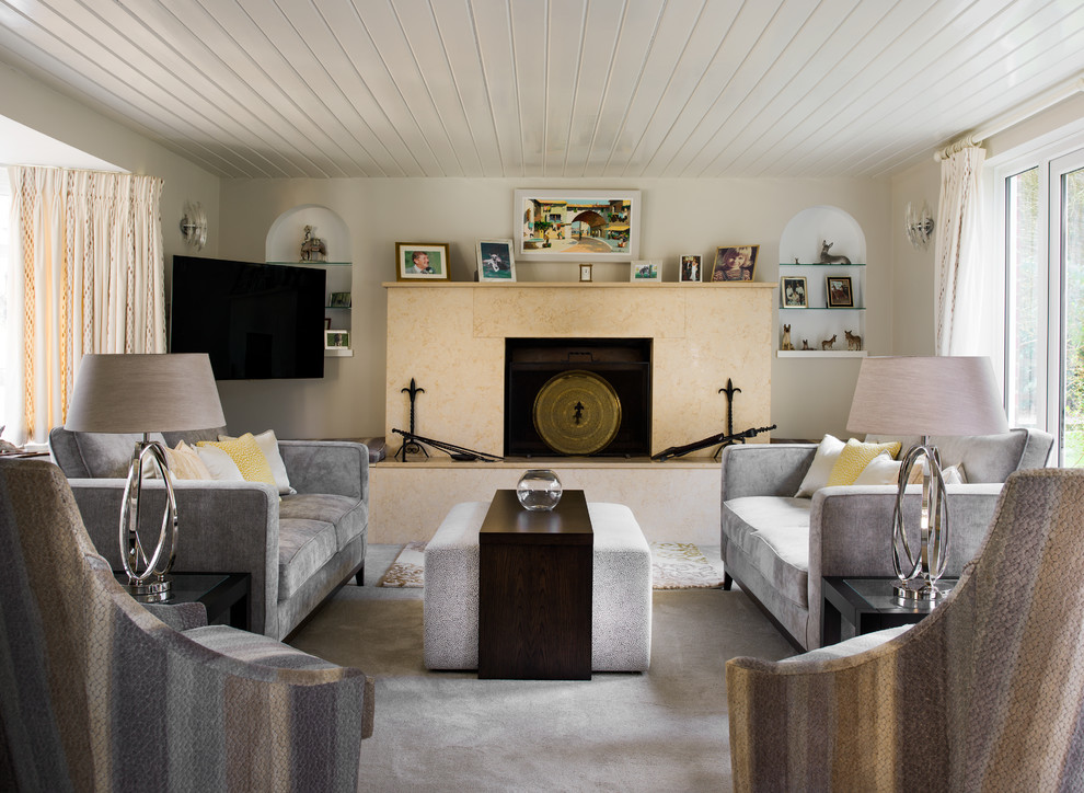 Foto di un piccolo soggiorno mediterraneo con pareti beige, moquette, pavimento grigio, camino classico e TV a parete