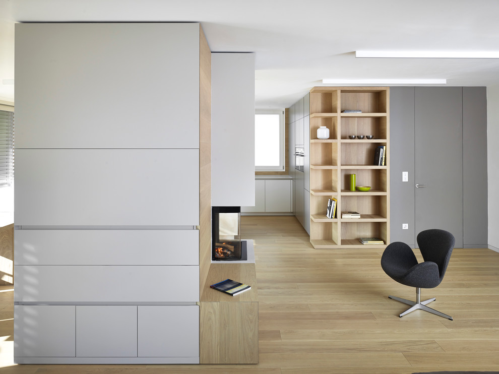 Offenes Modernes Wohnzimmer mit hellem Holzboden und grauer Wandfarbe in Sonstige