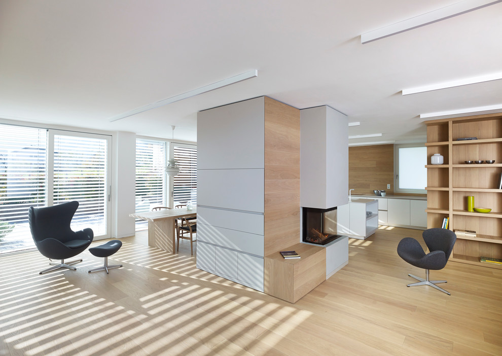 Contemporary open plan living room in Other with light hardwood flooring and white walls.