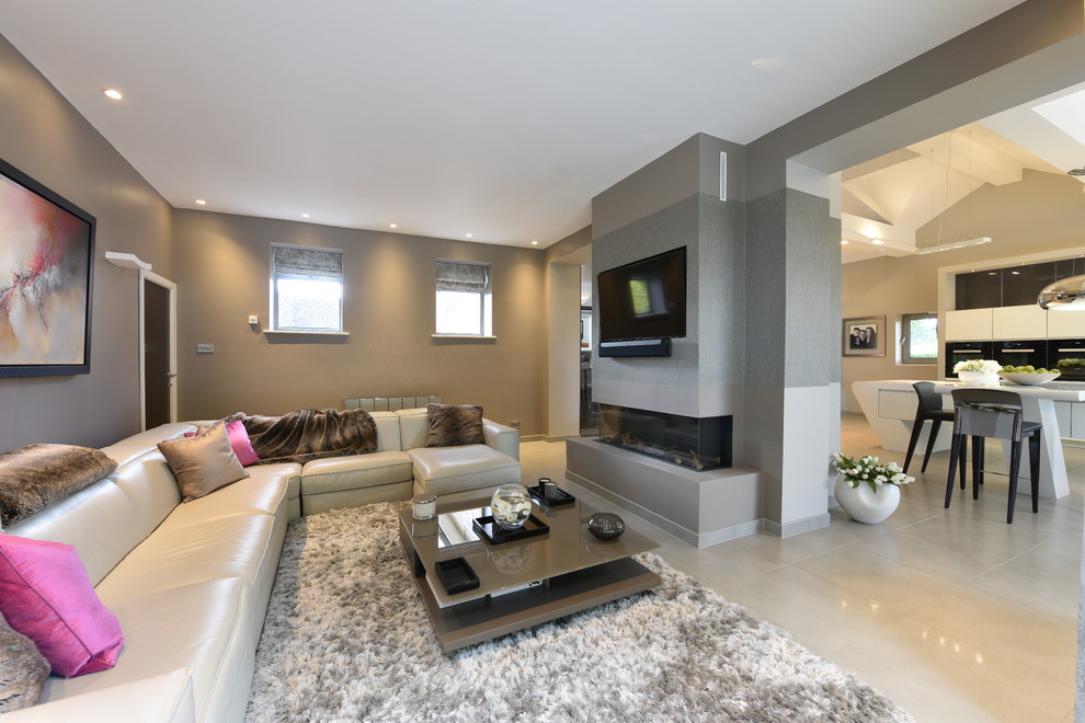 Exempel på ett mellanstort modernt allrum med öppen planlösning, med klinkergolv i porslin, beiget golv, grå väggar, en dubbelsidig öppen spis, en spiselkrans i gips och en väggmonterad TV