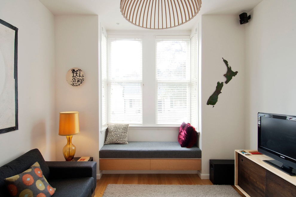 Idées déco pour un petit salon contemporain ouvert avec un mur blanc et un sol en bois brun.