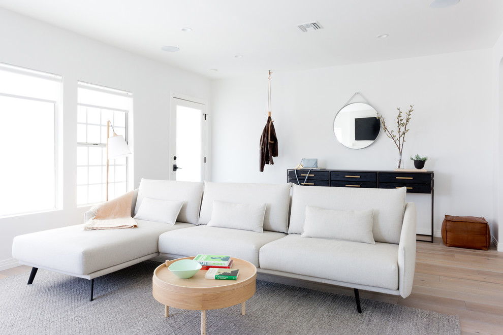 Design ideas for a scandi living room in Los Angeles with white walls and light hardwood flooring.