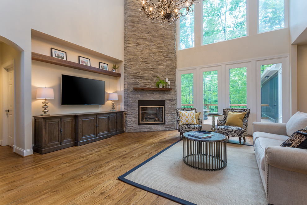 This is an example of a large classic open plan living room in Raleigh with grey walls, dark hardwood flooring, a corner fireplace and a stone fireplace surround.