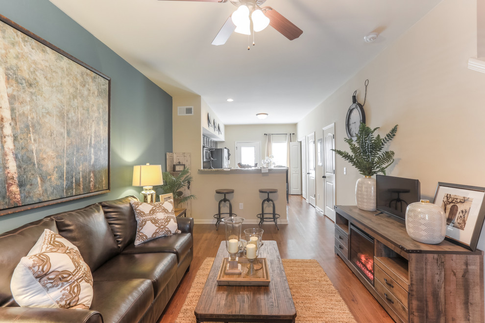 Living room - small contemporary open concept medium tone wood floor living room idea in Nashville with beige walls and no fireplace