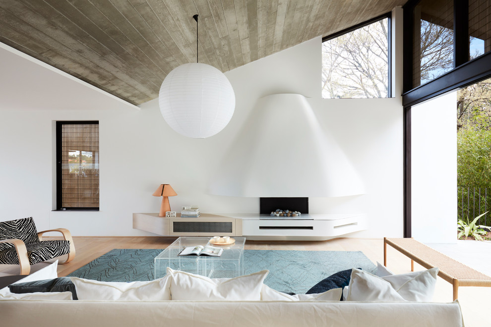 Пример оригинального дизайна: гостиная комната в стиле модернизм с белыми стенами, светлым паркетным полом, стандартным камином и коричневым полом