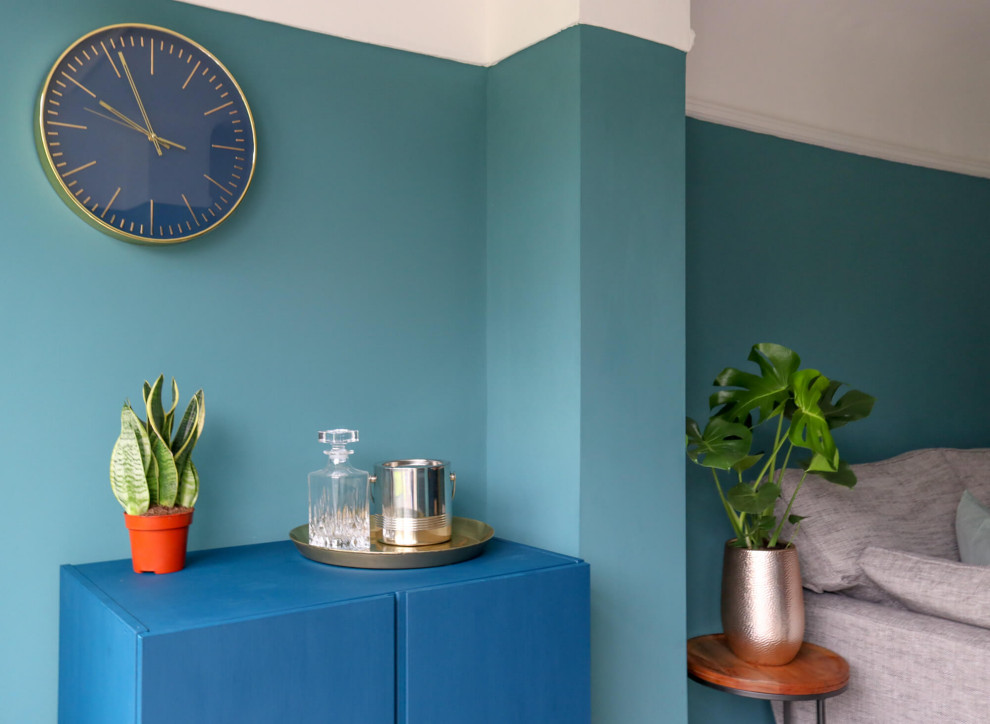 Стильный дизайн: изолированная гостиная комната среднего размера в стиле модернизм с домашним баром, синими стенами, полом из ламината, фасадом камина из дерева, телевизором на стене и коричневым полом без камина - последний тренд
