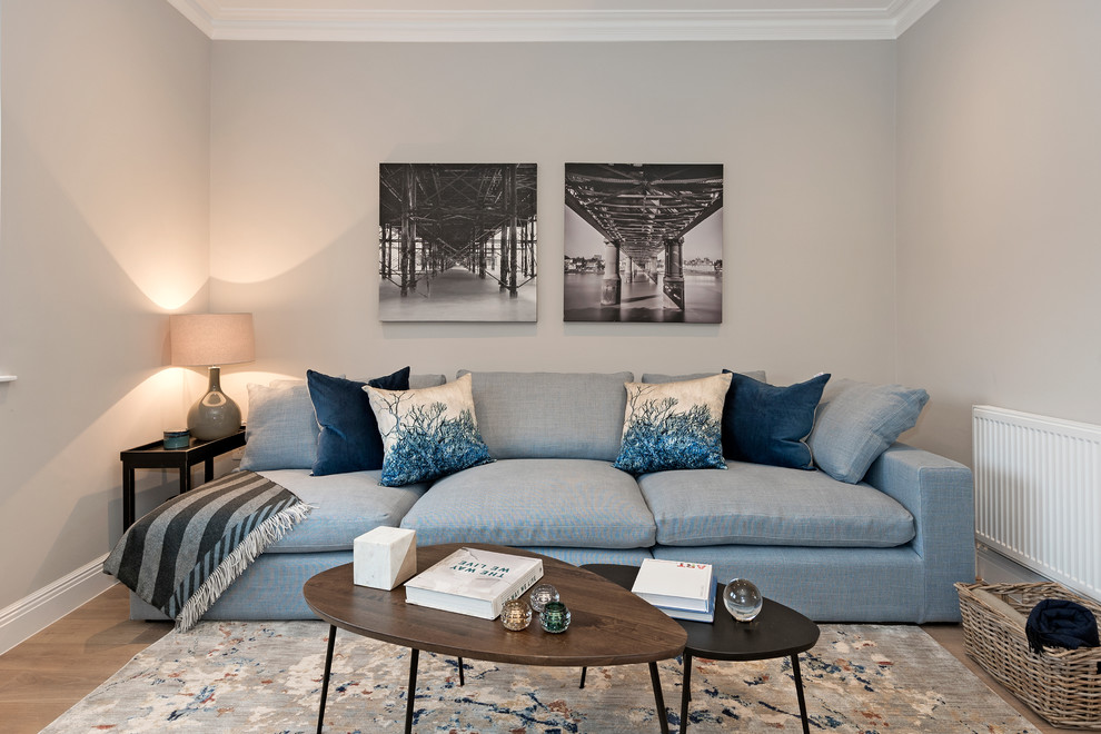 Foto de salón para visitas abierto tradicional de tamaño medio con paredes grises, suelo de madera clara, televisor independiente y suelo beige