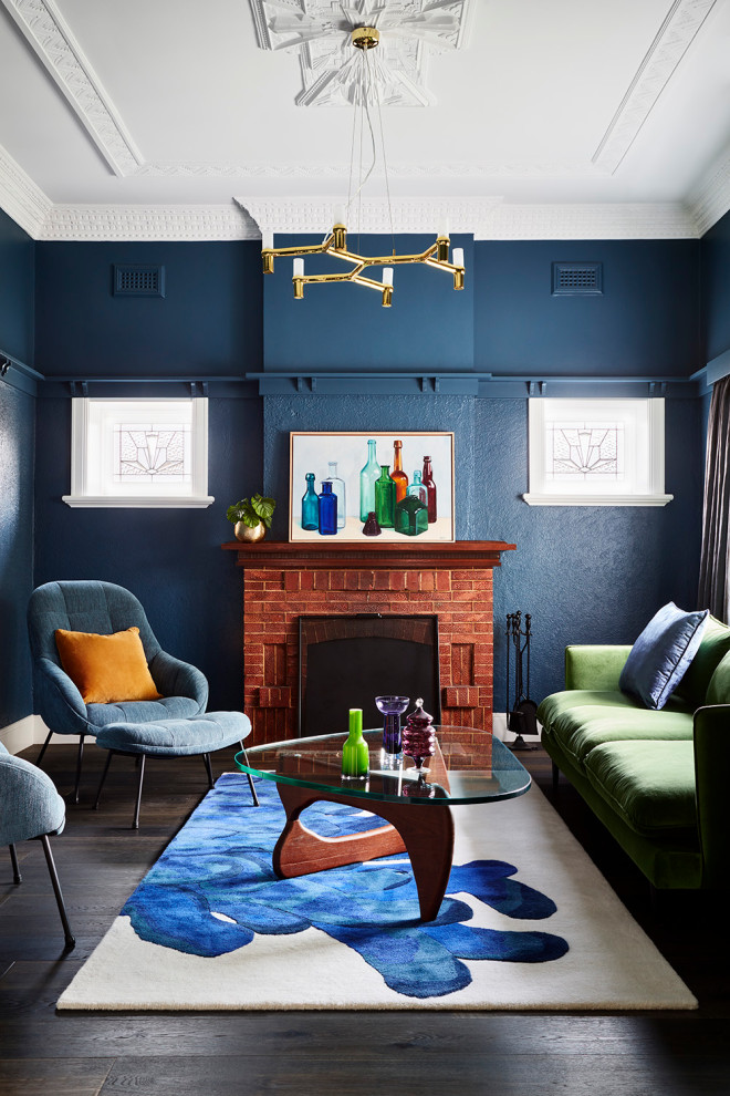 Idée de décoration pour un salon tradition de taille moyenne et ouvert avec un mur bleu, parquet foncé, une cheminée standard, un manteau de cheminée en brique, aucun téléviseur et un sol marron.