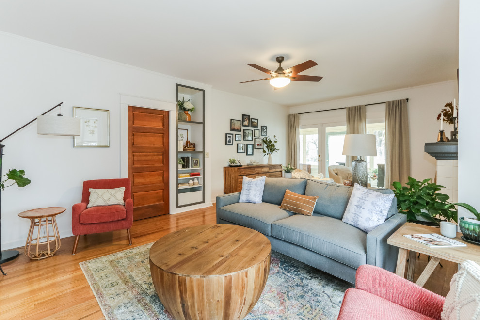 Kleines, Abgetrenntes Eklektisches Wohnzimmer mit weißer Wandfarbe, braunem Holzboden, Kamin, gefliester Kaminumrandung, freistehendem TV und braunem Boden in Seattle