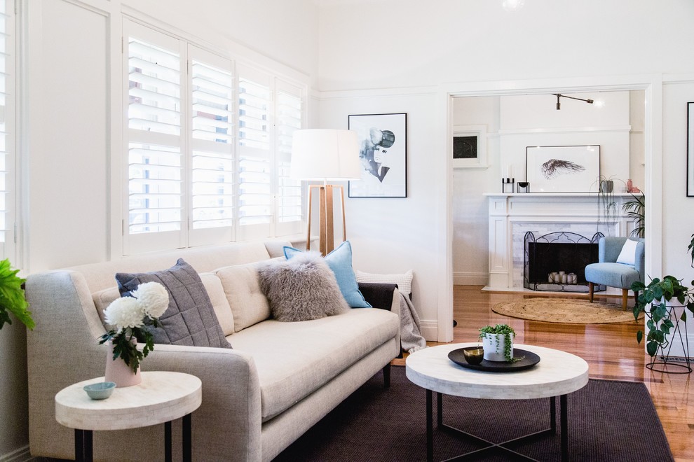 Large scandi living room in Melbourne with white walls and medium hardwood flooring.
