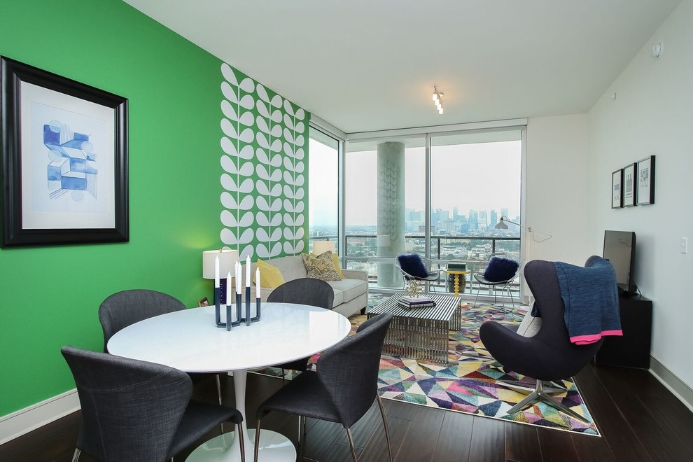 Aménagement d'un salon moderne de taille moyenne et ouvert avec un mur vert, parquet foncé, un téléviseur indépendant et un sol marron.