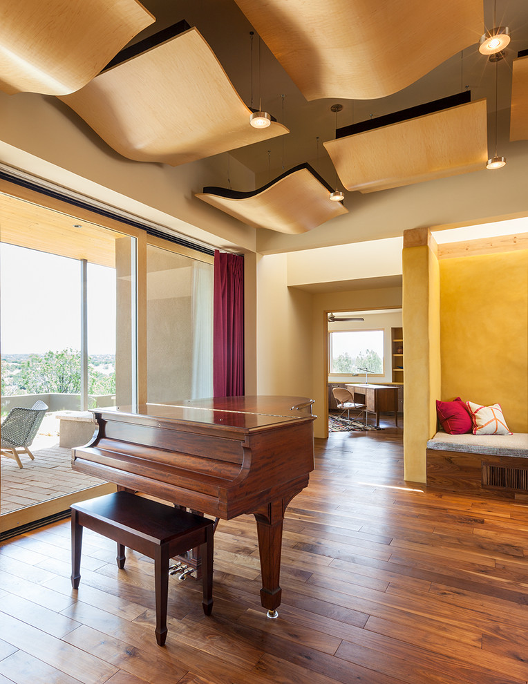 Mittelgroßes, Offenes Modernes Musikzimmer mit gelber Wandfarbe, braunem Holzboden und braunem Boden in Albuquerque