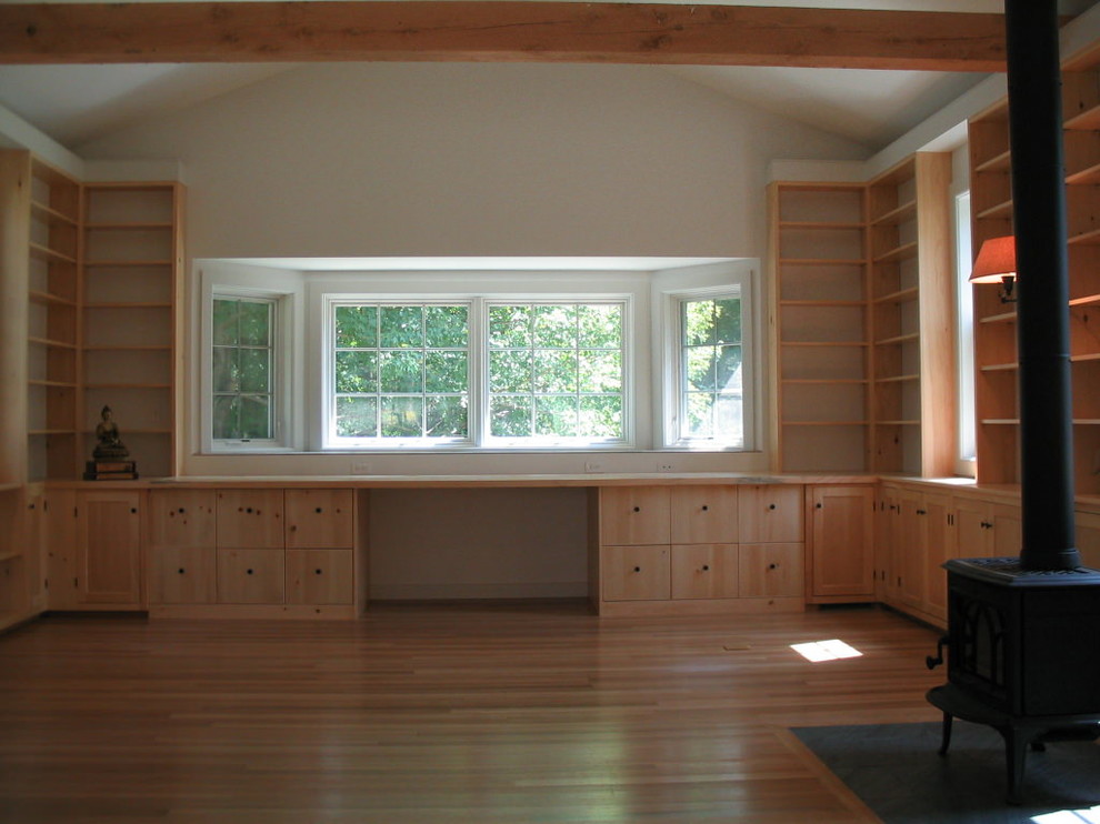 Modelo de biblioteca en casa rural de tamaño medio con paredes blancas y suelo de madera clara