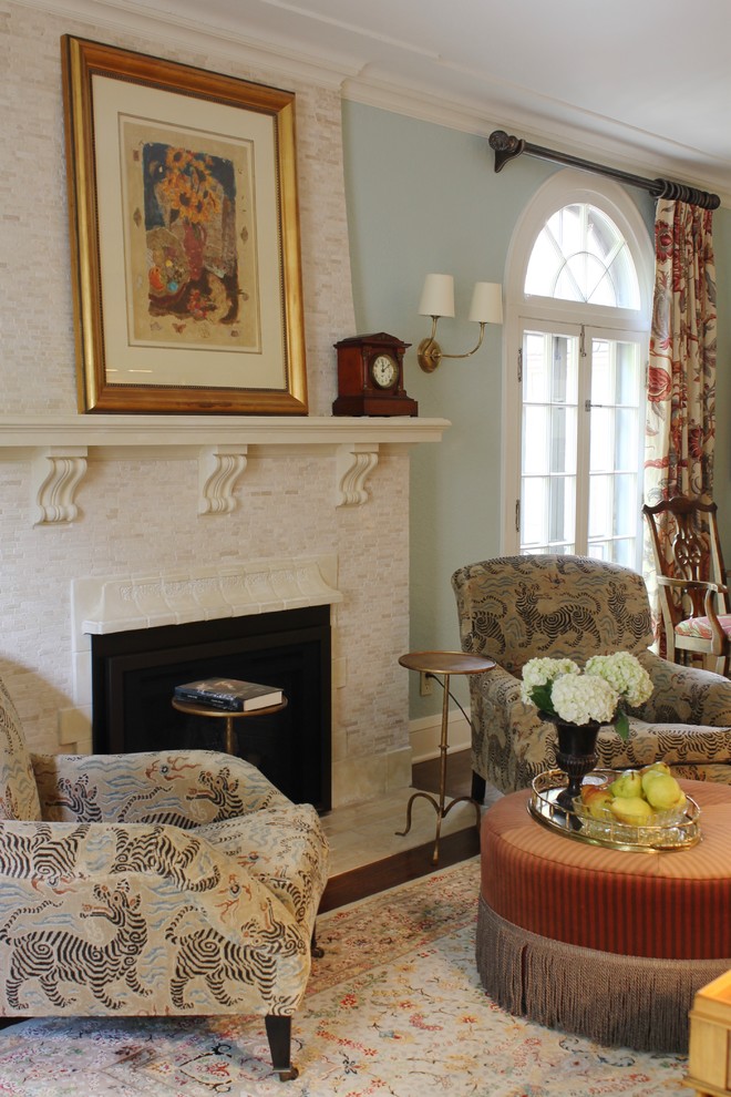 Immagine di un soggiorno chic con sala della musica, pareti blu, parquet chiaro, camino classico, cornice del camino in pietra e nessuna TV