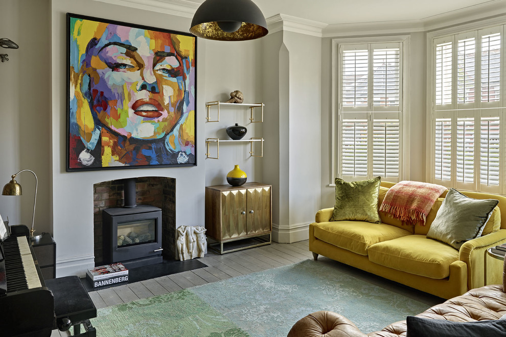 Repräsentatives, Abgetrenntes Modernes Wohnzimmer mit grauer Wandfarbe, braunem Holzboden, Kaminofen, Kaminumrandung aus Metall und grauem Boden in London