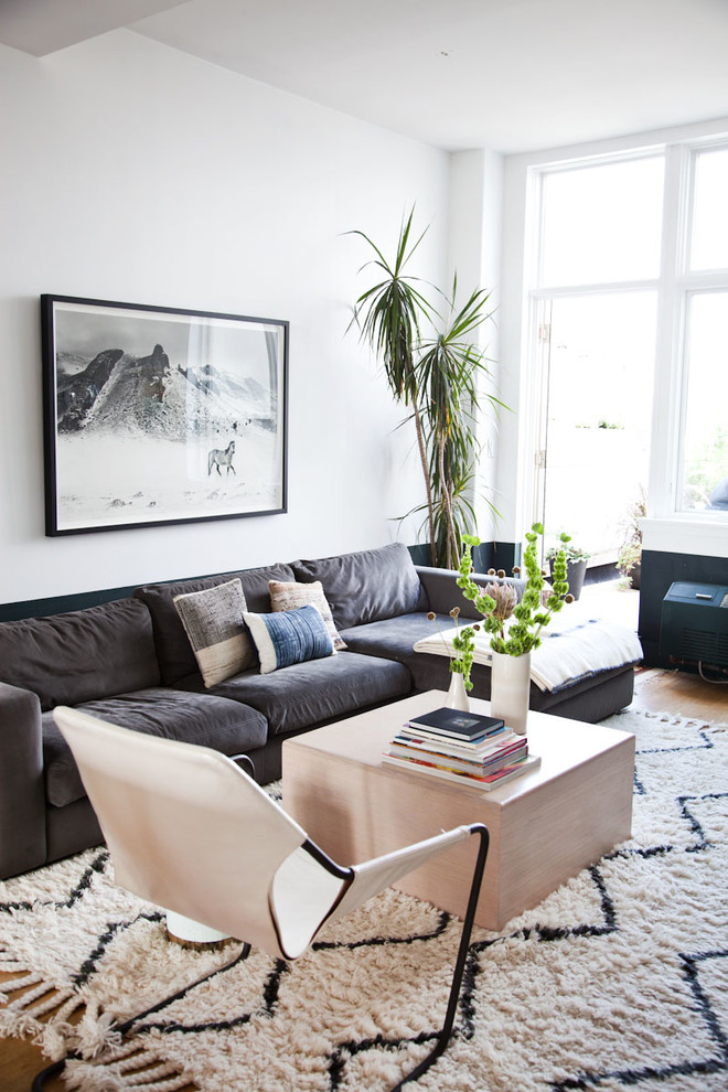 Diseño de salón abierto minimalista de tamaño medio con suelo de madera clara, televisor colgado en la pared y paredes multicolor