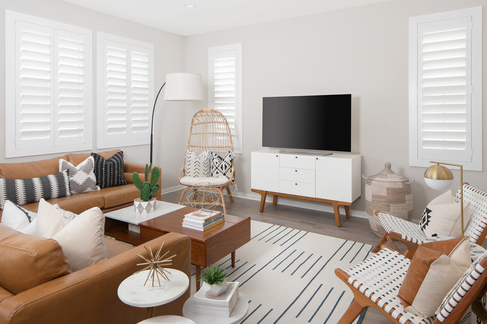 Immagine di un soggiorno tradizionale con pareti grigie, pavimento in legno massello medio, TV autoportante e pavimento marrone