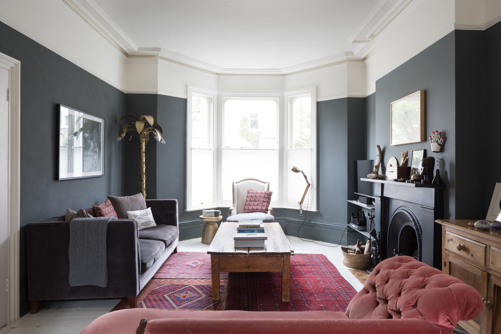 ロンドンにあるコンテンポラリースタイルのおしゃれなリビング (黒い壁、塗装フローリング、標準型暖炉、白い床、ペルシャ絨毯) の写真