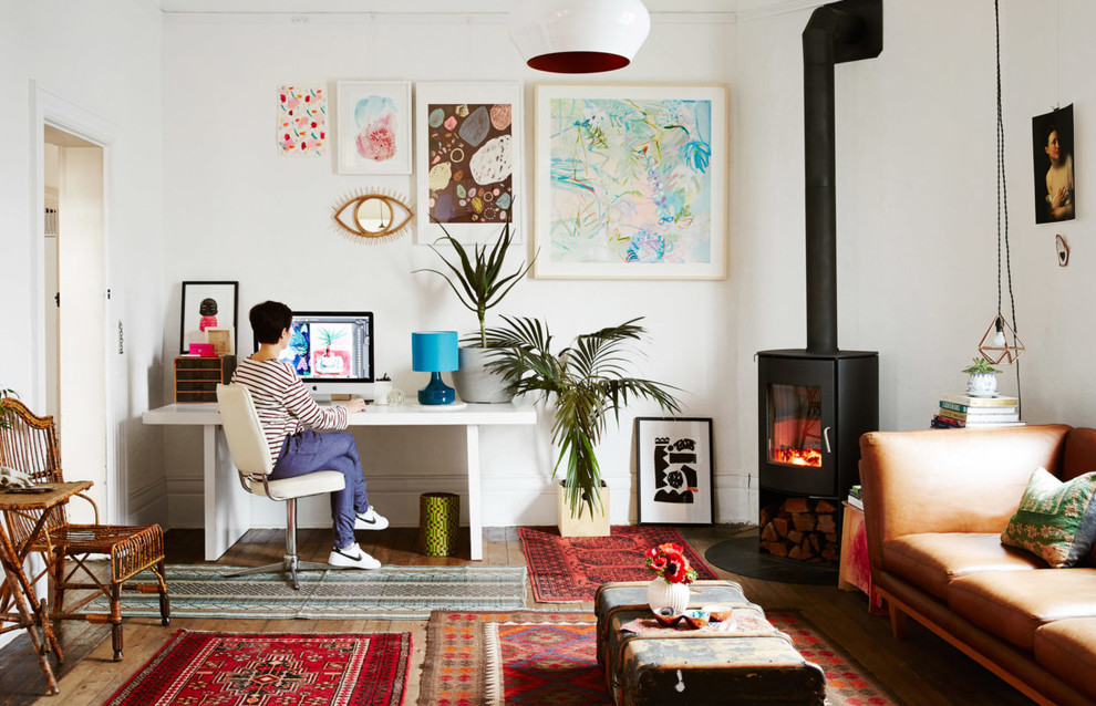 Fernseherloses, Abgetrenntes Stilmix Wohnzimmer mit weißer Wandfarbe, braunem Holzboden, Kaminofen und Kaminumrandung aus Metall in Melbourne