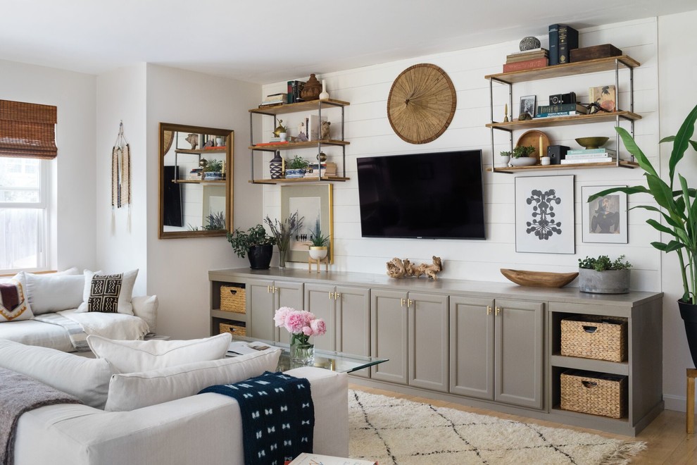 Stilmix Wohnzimmer mit weißer Wandfarbe, braunem Holzboden, TV-Wand und braunem Boden in Boston