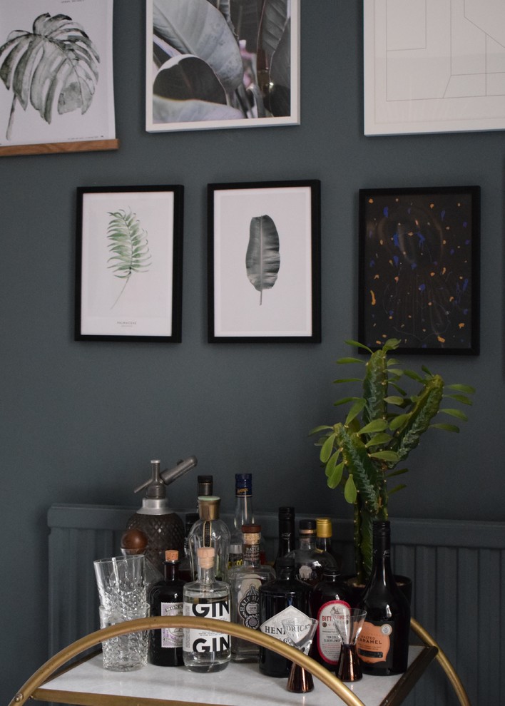 Medium sized eclectic enclosed living room in London with blue walls, light hardwood flooring, no fireplace, a stone fireplace surround, brown floors and a home bar.