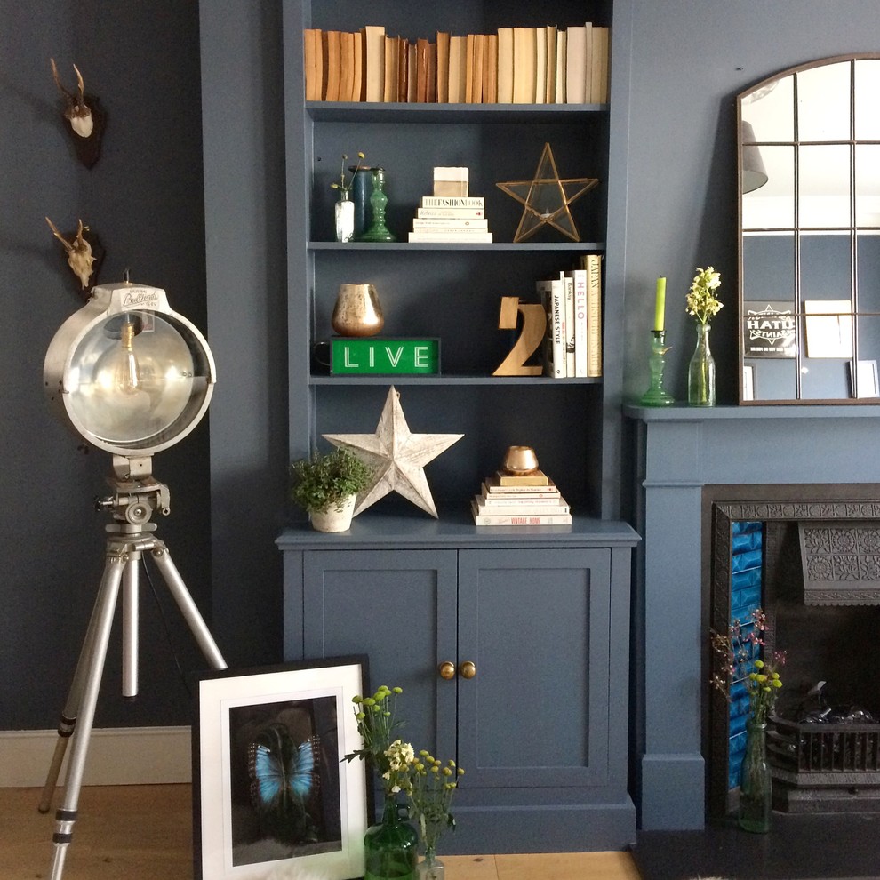Mid-sized transitional formal and enclosed living room photo in London with blue walls and a concealed tv
