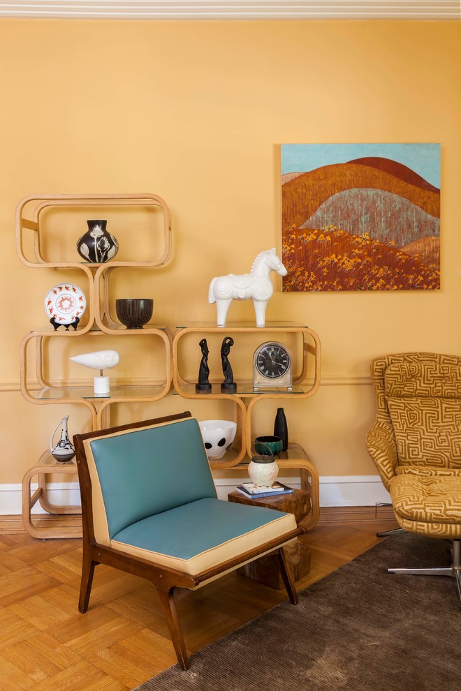 Bild på ett mellanstort funkis separat vardagsrum, med ett finrum, ljust trägolv, en öppen hörnspis, en spiselkrans i trä, en fristående TV och gula väggar