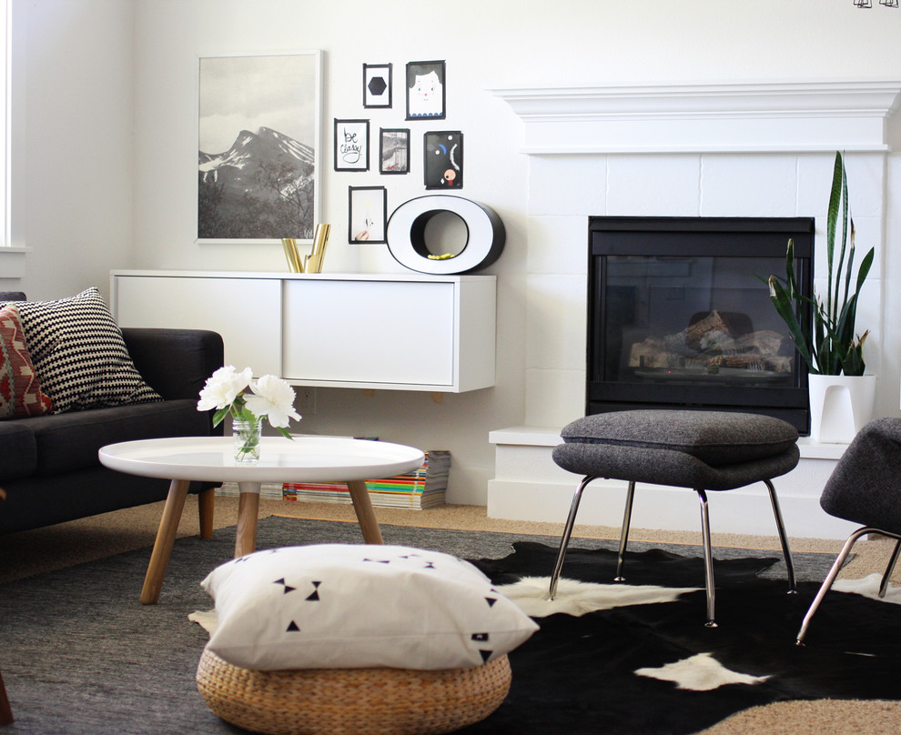 Aménagement d'un salon scandinave avec un mur blanc et une cheminée standard.